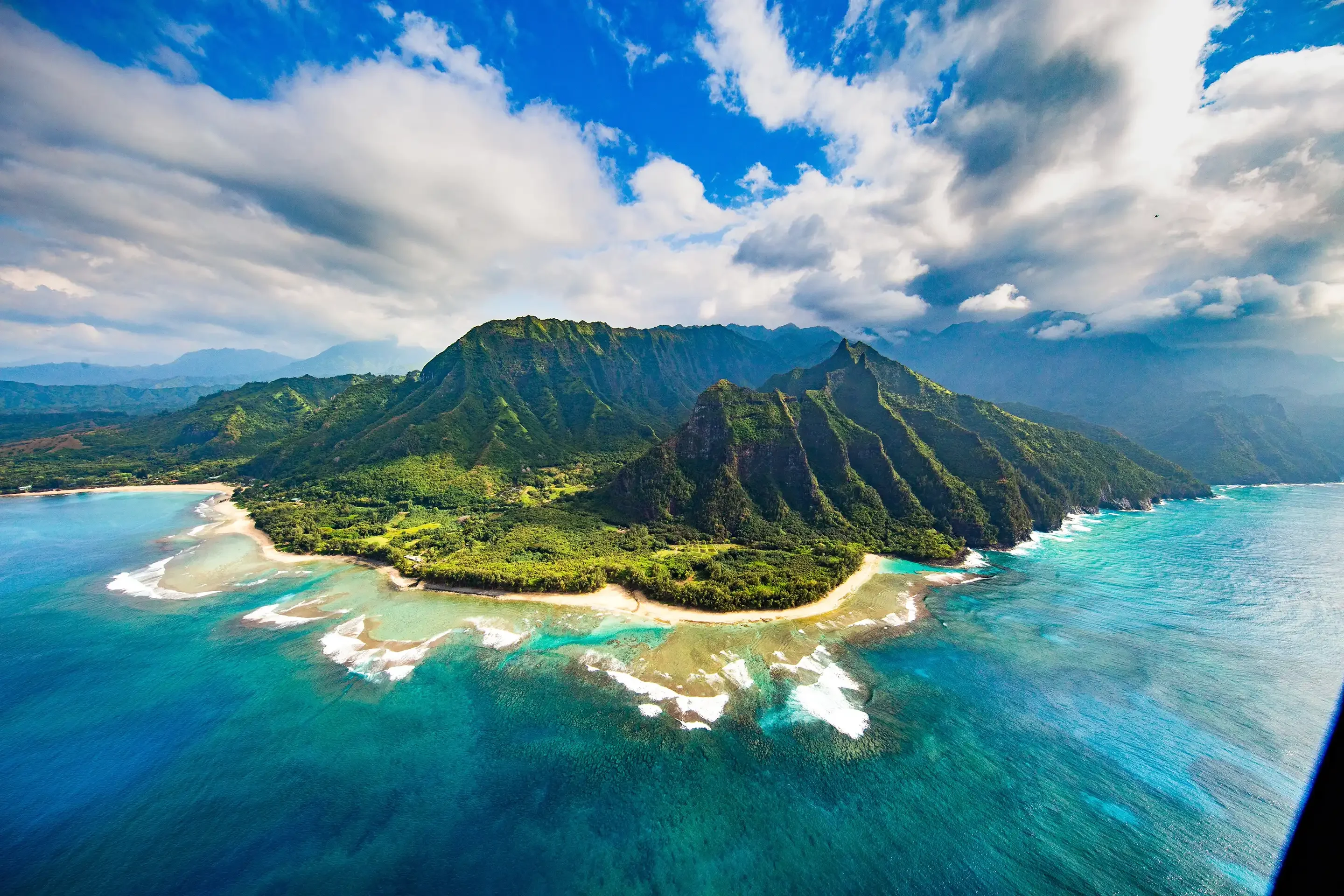 Côte de Na Pali vue du ciel, falaises verdoyantes plongeant dans un lagon turquoise